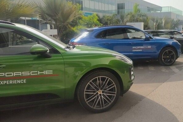 Green and Blue Color Porsche Macan Adjacent to Each Other Side Profiles